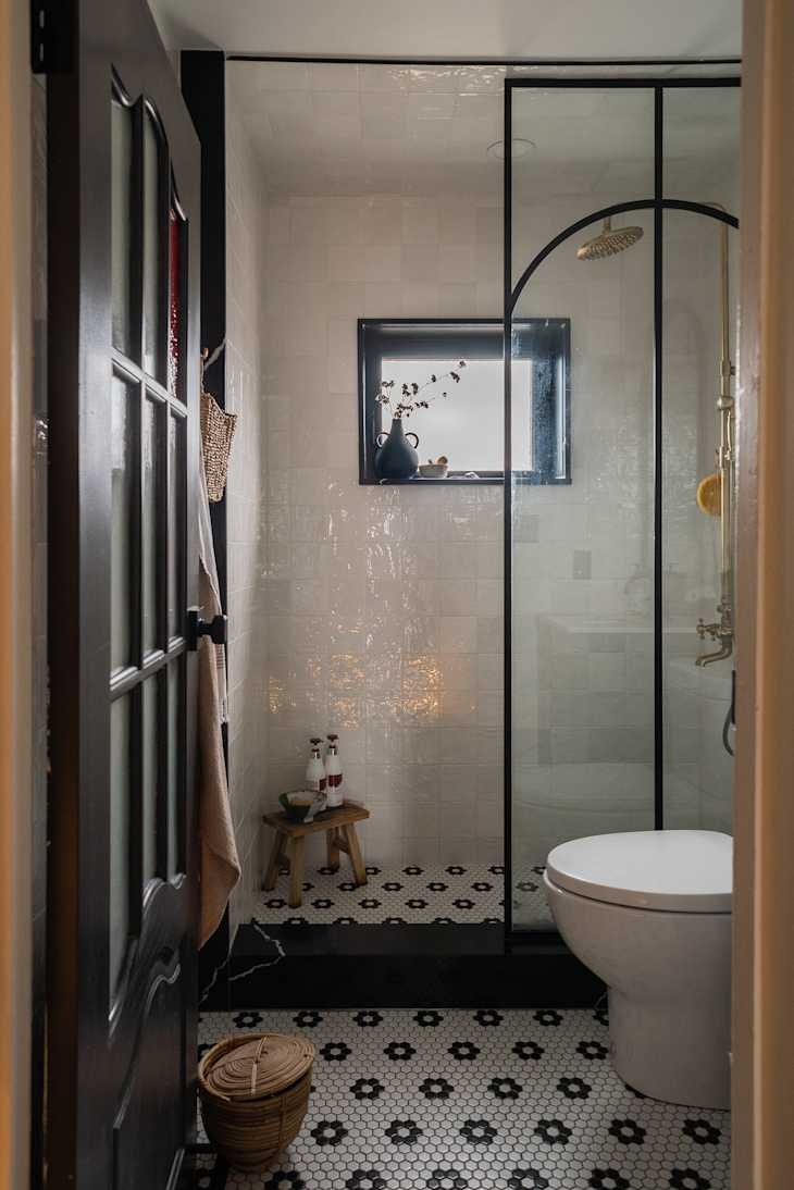 A bathroom with tile floors and a large glass shower.
