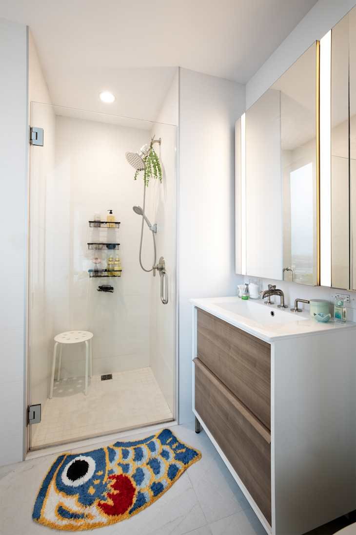 Waterfall shower faucet in white bathroom.